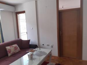 ein Wohnzimmer mit einem Sofa und einem Tisch in der Unterkunft Wohnung nähe Stadtzentrum in Zenica