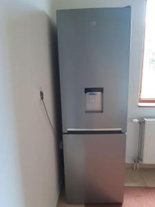 einen silbernen Kühlschrank in einem Zimmer mit Fenster in der Unterkunft Wohnung nähe Stadtzentrum in Zenica