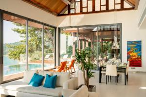 een open woonkamer met een witte bank en een tafel bij Malaiwana Villa N in Nai Thon Beach