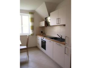 a kitchen with white cabinets and a sink and a window at Holiday apartment summer Wachau 2 in Spitz +12 photos