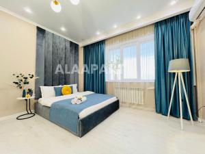 a bedroom with a blue bed and a window at 396I1 Blue Horizon Apartments Sholpan city in Almaty