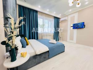 a bedroom with a bed and a table at 396I1 Blue Horizon Apartments Sholpan city in Almaty +22 photos