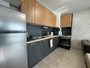 a kitchen with wooden cabinets and a stainless steel refrigerator at Panoramic view near Sofia Airport in Sofia