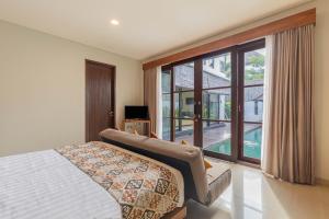 sypialnia z łóżkiem i dużym oknem w obiekcie The BALIem Villa w mieście Jimbaran