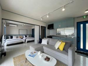 ein Wohnzimmer mit einem Sofa und einem Bett in der Unterkunft bLOCAL AO house - 1 BR House with Ocean View Few min walk to the beach in Suo Oshima