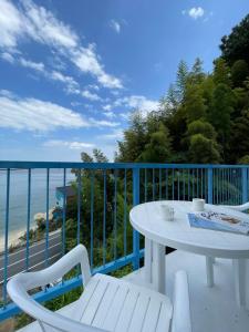 uma varanda com uma mesa e cadeiras e o oceano em bLOCAL AO house - 1 BR House with Ocean View Few min walk to the beach em Suo Oshima