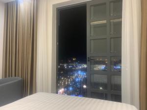 1 dormitorio con ventana y vistas a la ciudad en Hà Hùng Panorama Hotel en Ha Tien
