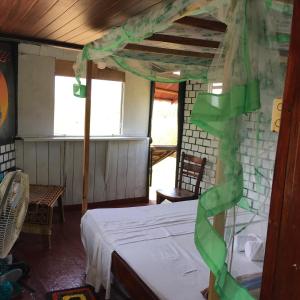 a bedroom with a bed with a green ribbon on it at Little birds in Tangalle