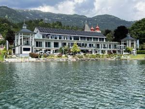 a large building next to a large body of water at House Lammersdorf in Millstatt