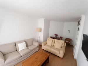 uma sala de estar com dois sofás brancos e uma mesa em Light House Sherry em Jerez de la Frontera
