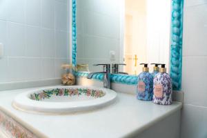 La salle de bains est pourvue d'un lavabo avec 2 bouteilles. dans l'établissement Light House Sherry, à Jerez de la Frontera