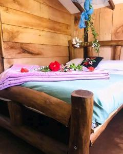 łóżko w drewnianym pokoju z kwiatami w obiekcie The Paulwood cabana home stay w mieście Nuwara Eliya