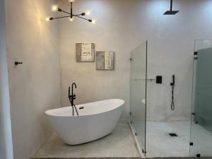 a white bath tub in a bathroom with a shower at CASA LUNA ¡Piscina y Playa! in La Ceiba