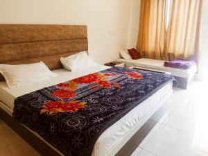 a hotel room with two beds with flowers on the blanket at Hotel Lake View Paradise in Uttarkāshi