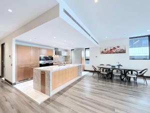 Grand St Kilda 2-story Sub-Penthouse في ملبورن: مطبخ وغرفة طعام مع طاولة وكراسي