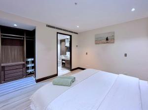 1 dormitorio con 1 cama blanca grande y baño en Grand St Kilda 2-story Sub-Penthouse, en Melbourne