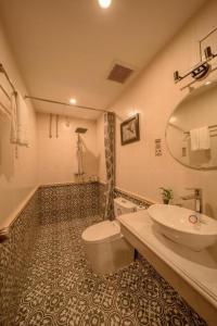 Un baño con lavabo, inodoro y espejo. en Bonjour D'An Nam Hotel HN - by BAY LUXURY, en Hanói