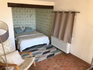 a small bedroom with a bed and a chair at ST FRANCOIS in Grasse