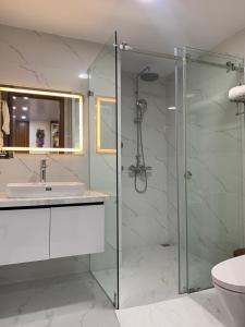 y baño con ducha acristalada y lavamanos. en BaoTran Apartment & hotel, en Ðông Khê