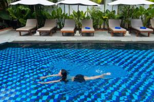 Eine Frau schwimmt im Pool in der Unterkunft Angkor Land Urban Boutique in Siem Reap