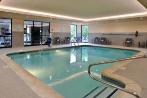 a large swimming pool in a hotel lobby at Courtyard Detroit Utica in Utica