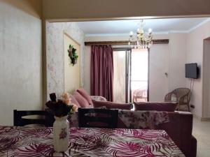 een woonkamer met een bank en een eettafel bij Cozy apartment Maadi Ring road in Caïro