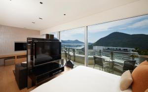 a bedroom with a tv and a large window at Nina Hotel Island South in Hong Kong