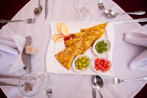 un piatto bianco con pizza, patatine fritte e verdure di Filagot Hotel a Adama