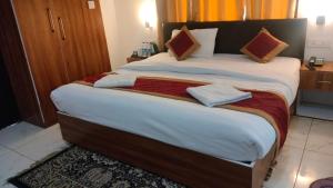 ein großes Bett mit zwei Handtüchern darauf in einem Zimmer in der Unterkunft Seven Corbett in Rāmnagar