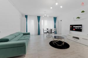 ein Wohnzimmer mit einem grünen Sofa und einem Tisch in der Unterkunft New World Militari Grand Studio 2 in Bukarest