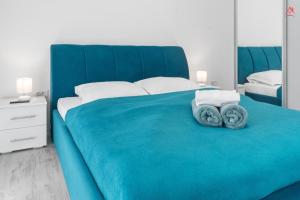 Una cama azul con dos toallas encima. en New World Militari Grand Studio 2, en Bucarest