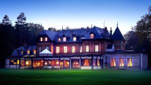 une grande maison éclairée dans la cour dans l'établissement Le Pavillon De Gouffern, à Silli-en-Gouffern