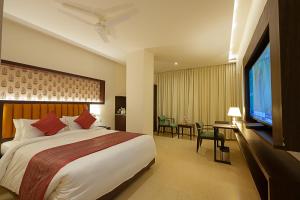 a hotel room with a large bed and a flat screen tv at Grand Continent Secunderabad A Sarovar Portico Affiliate Hotel in Secunderabad