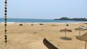 a beach with many straw umbrellas and the ocean at Royal cottage in Palolem
