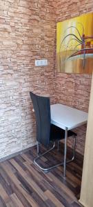 a desk and a chair in a room with a painting at Pension Haus am Malesfelsen in Albstadt