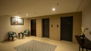 - une salle d'attente avec quatre portes, une table et des chaises dans l'établissement Grand Continent Secunderabad A Sarovar Portico Affiliate Hotel, à Secunderābād