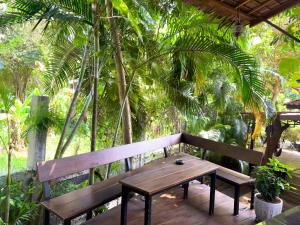 a wooden bench sitting on top of a wooden deck at Jungle Vibes in Thong Sala