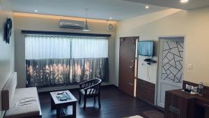 Kizhake ChālakudiAthirappilly Polaris Resort的带椅子和桌子的客厅