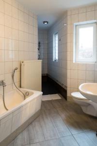 a bathroom with a tub and a toilet and a sink at Studiowohnungen Am Neuberinhaus F&G Apartments in Reichenbach im Vogtland