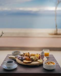 un plateau de nourriture sur une table en bois avec une assiette de nourriture dans l'établissement Hotel Kyani Akti, à Xylokastro