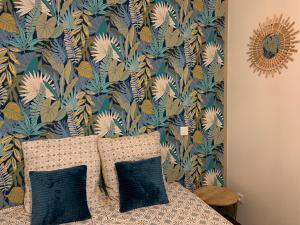 - une chambre dotée d'un lit avec du papier peint bleu et jaune dans l'établissement Aix'quis - appartement 51 m2, à Aix-les-Bains