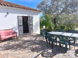 un patio con mesa y sillas frente a una casa en Finca el Berezal, en Aracena