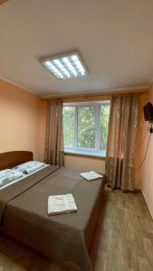 Un dormitorio con una cama grande y una ventana en База відпочинку «Павлоградець», en Orlovshchina