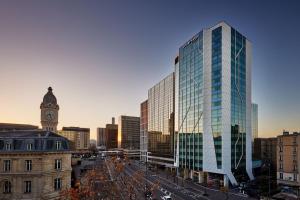 un edificio alto de cristal en una ciudad con una torre de reloj en Courtyard by Marriott Paris Gare de Lyon en París