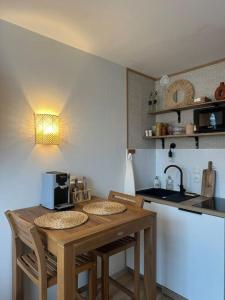 eine kleine Küche mit einem Holztisch und Stühlen in der Unterkunft Studio avec accès plage et mer in Dinard