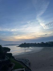 einen Blick auf den Strand bei Sonnenuntergang mit dem Meer in der Unterkunft Studio avec accès plage et mer in Dinard