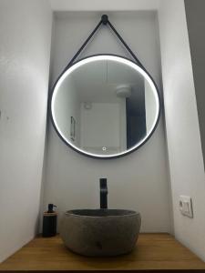 ein Bad mit einem runden Waschbecken und einem Spiegel in der Unterkunft Studio avec accès plage et mer in Dinard