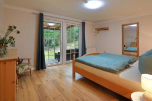 um quarto com uma cama e uma grande janela em Forsthaus Heidelberg Prignitz 