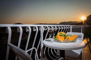 a plate of fruit on a table on a balcony at Studio Apartments Andrijana in Mlini