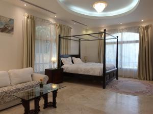 a bedroom with a canopy bed and a couch at Stay House in Dubai in Dubai